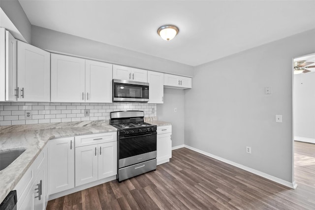 kitchen with stainless steel appliances, white cabinetry, light stone countertops, and tasteful backsplash