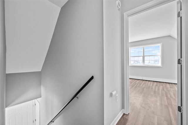 stairway featuring vaulted ceiling and hardwood / wood-style floors