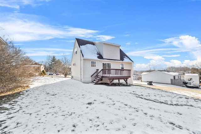 snow covered rear of property featuring a deck