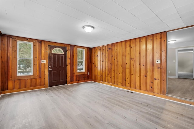 entrance foyer with light hardwood / wood-style flooring and wood walls