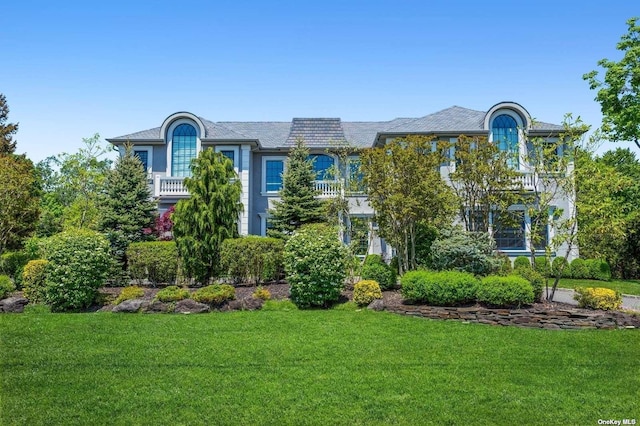 view of front of home with a front lawn and a balcony