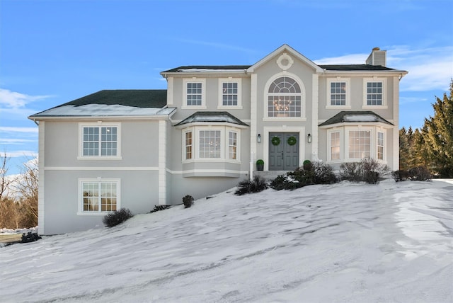 view of front of home featuring a chimney and stucco siding