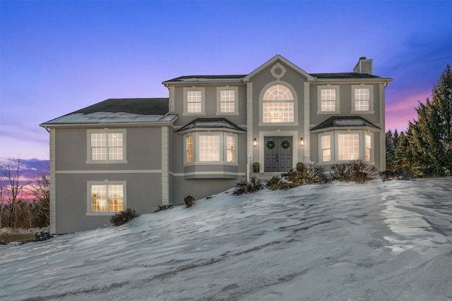 view of front of home featuring french doors, a chimney, and stucco siding