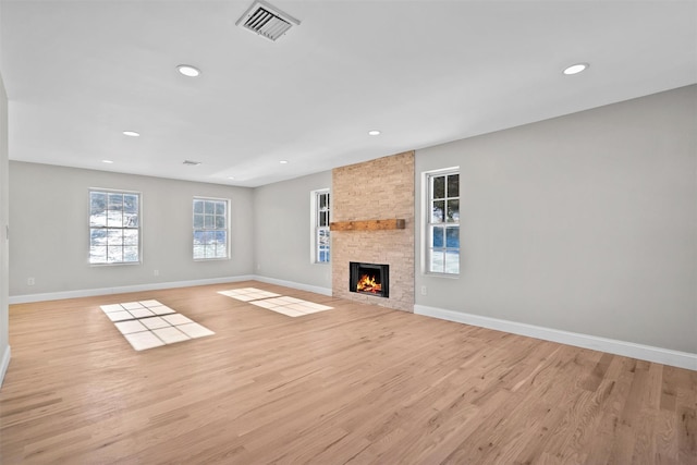 unfurnished living room with light wood-style flooring, visible vents, and baseboards