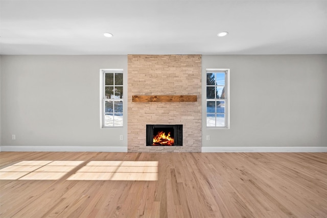 unfurnished living room with light wood finished floors, baseboards, and recessed lighting