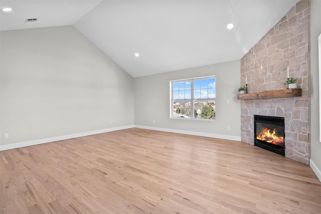 unfurnished living room featuring visible vents, baseboards, light wood-style flooring, vaulted ceiling, and a fireplace