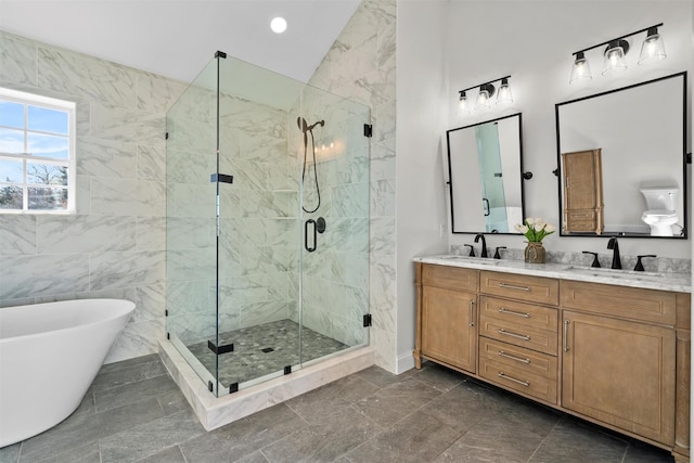 bathroom with a stall shower, a freestanding tub, a sink, and double vanity