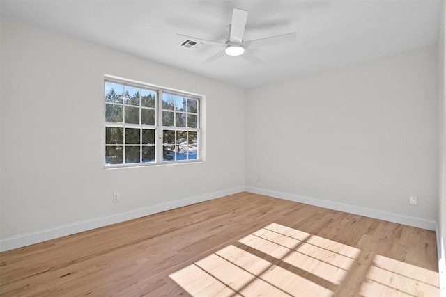 empty room with visible vents, ceiling fan, light wood-style flooring, and baseboards