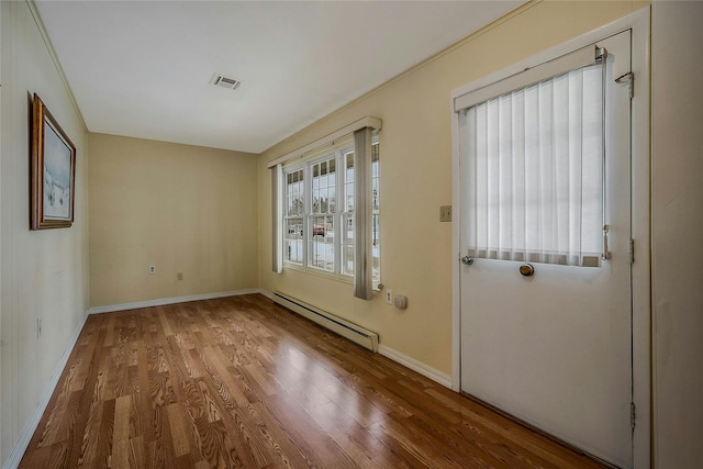 entryway with baseboards, a baseboard radiator, visible vents, and wood finished floors