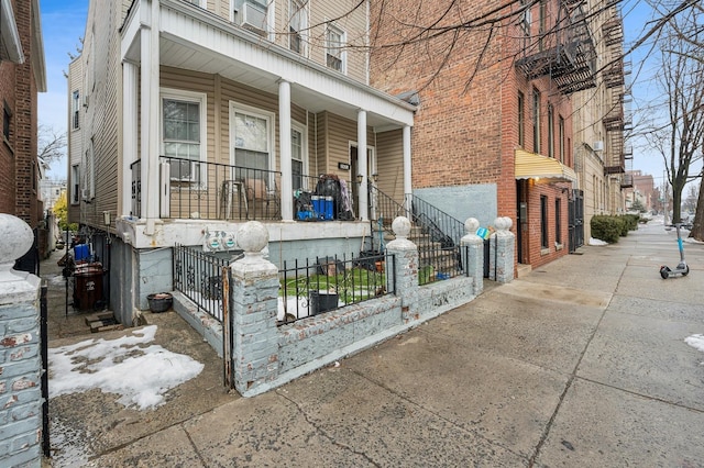 view of home's exterior with covered porch and a fenced front yard