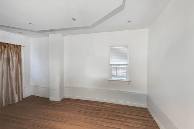 empty room featuring dark wood-style flooring, recessed lighting, and baseboards