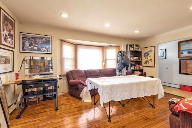 bedroom with light wood-type flooring, a baseboard radiator, and recessed lighting