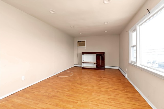 unfurnished living room with recessed lighting, a wall mounted air conditioner, baseboards, and light wood finished floors