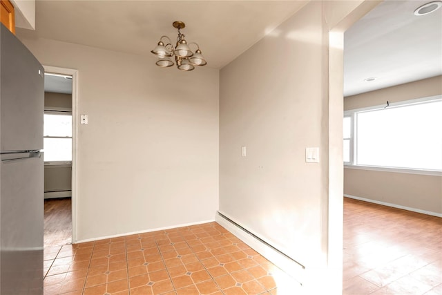 empty room featuring a baseboard radiator, a chandelier, baseboard heating, and baseboards