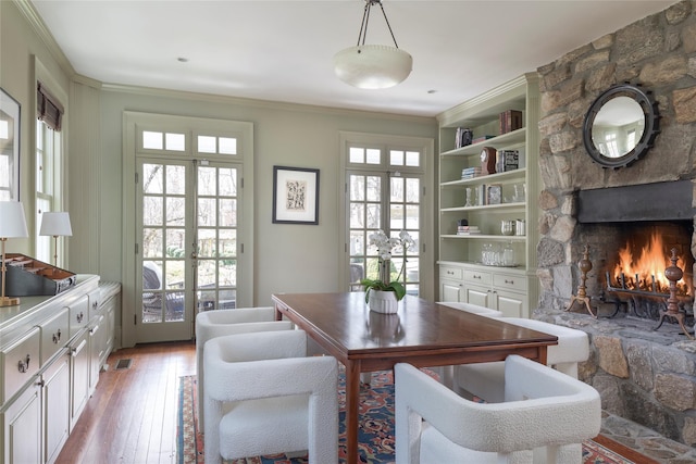 500 Hardscrabble Rd, Briarcliff Manor, NY 10510 - dining area featuring light wood finished floors, crown molding, a stone fireplace, visible vents, and french doors