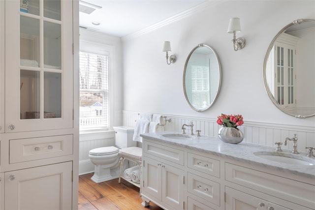 500 Hardscrabble Rd, Briarcliff Manor, NY 10510 - bathroom featuring wood finished floors, wainscoting, ornamental molding, toilet, and a sink