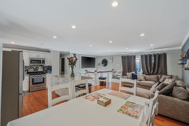 dining room featuring crown molding and light hardwood / wood-style floors