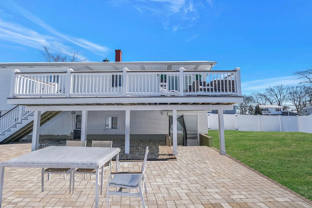 rear view of house featuring a lawn, a deck, and a patio area