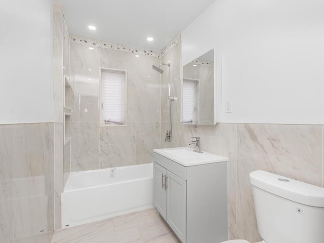 full bathroom with tiled shower / bath combo, vanity, tile walls, and toilet