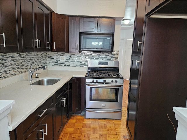 kitchen with stainless steel range with gas cooktop, black microwave, sink, backsplash, and light parquet flooring