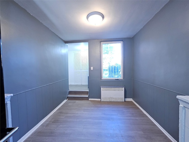 empty room with radiator and wood-type flooring