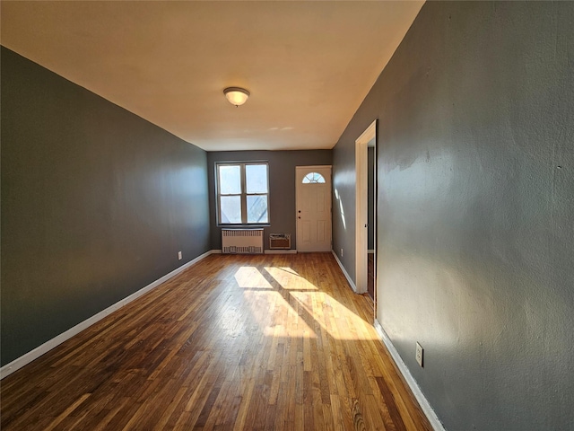 entryway with radiator and hardwood / wood-style floors