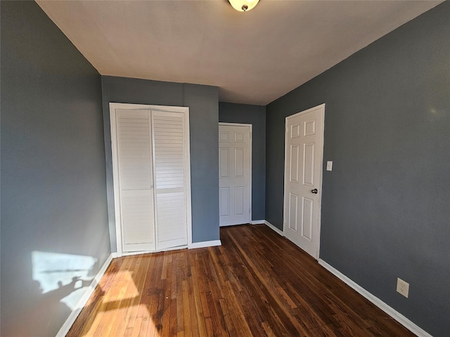 unfurnished bedroom featuring a closet and dark hardwood / wood-style floors