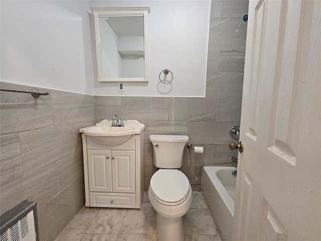 full bathroom featuring tiled shower / bath combo, vanity, tile walls, and toilet