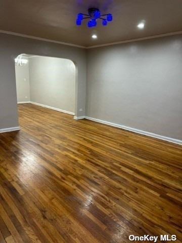 unfurnished room featuring ornamental molding and dark hardwood / wood-style flooring