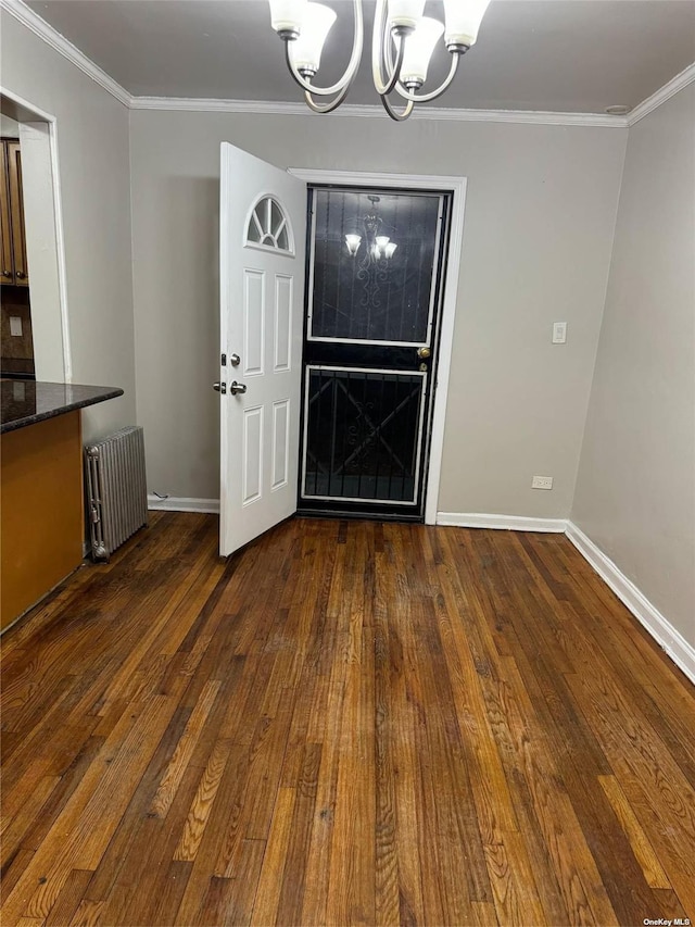 unfurnished dining area featuring dark hardwood / wood-style flooring, a notable chandelier, radiator heating unit, and ornamental molding