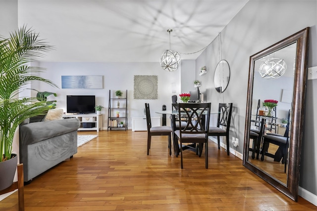 dining area featuring wood-type flooring and a notable chandelier