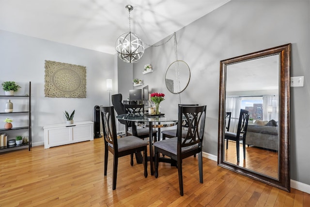 dining area featuring an inviting chandelier and hardwood / wood-style flooring