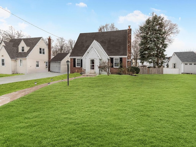 view of front of house featuring a garage, an outbuilding, and a front yard