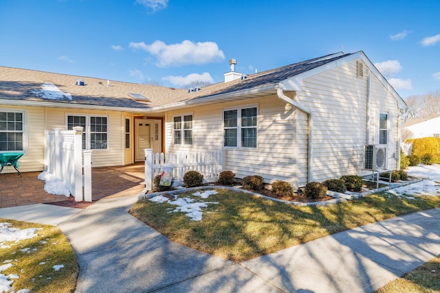 ranch-style house featuring ac unit and a front lawn