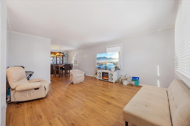 living room with crown molding, hardwood / wood-style flooring, and a chandelier