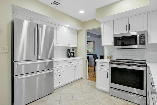 kitchen with stainless steel appliances, light countertops, white cabinets, and visible vents