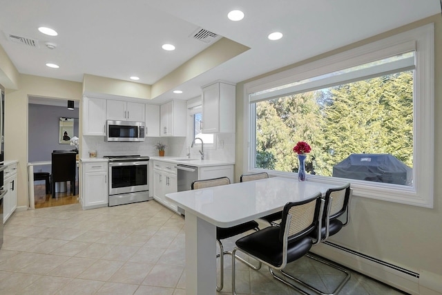 kitchen with visible vents, decorative backsplash, stainless steel appliances, light countertops, and a sink