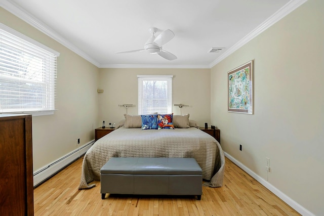 bedroom with a baseboard heating unit, light wood-type flooring, visible vents, and crown molding