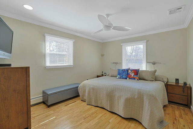 bedroom featuring a baseboard heating unit, visible vents, light wood-style floors, and crown molding