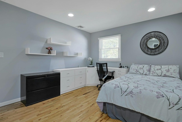 bedroom with recessed lighting, visible vents, built in desk, and light wood finished floors