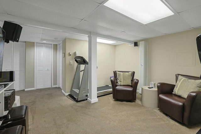 exercise room featuring a paneled ceiling, carpet flooring, and baseboards