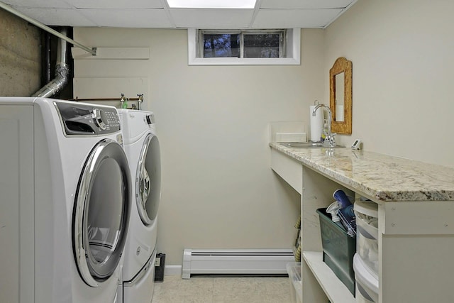 laundry room featuring laundry area, a baseboard heating unit, washer and clothes dryer, and a sink