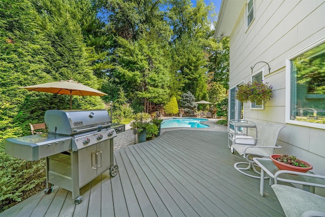 wooden terrace featuring an outdoor pool and area for grilling