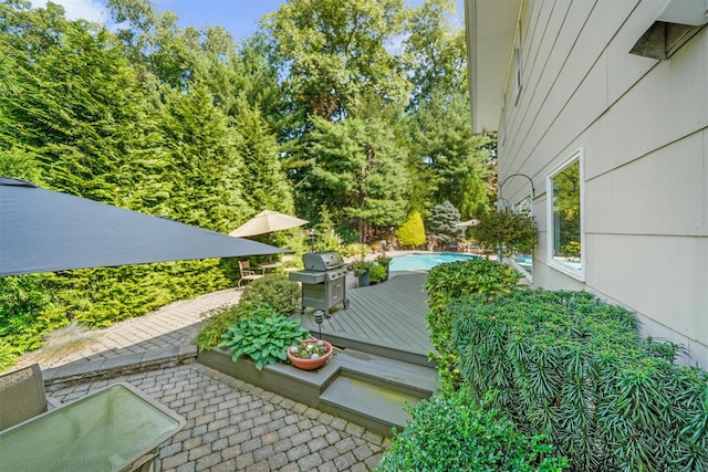 view of yard featuring a deck, a patio area, and an outdoor pool