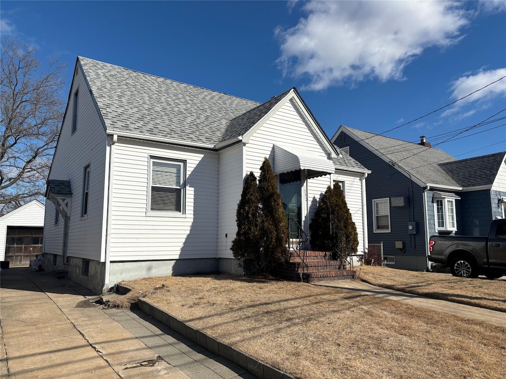 bungalow featuring a garage, concrete driveway, and roof with shingles