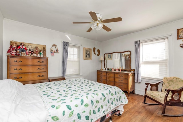 bedroom featuring ceiling fan, ornamental molding, and light hardwood / wood-style floors