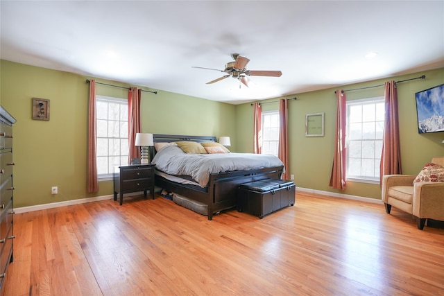 bedroom with a ceiling fan, light wood-style flooring, and baseboards