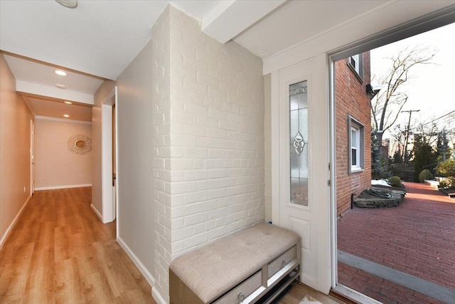 doorway with light wood-style floors, brick wall, baseboards, and recessed lighting