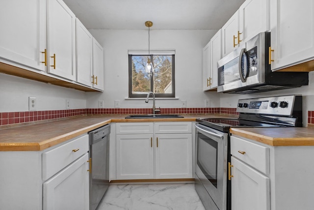 kitchen with stainless steel appliances, marble finish floor, white cabinets, and a sink