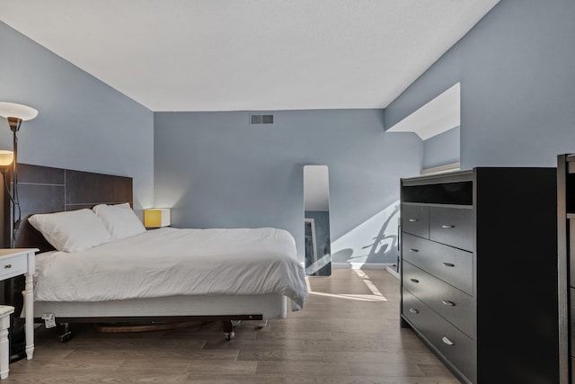 bedroom featuring visible vents, baseboards, and wood finished floors